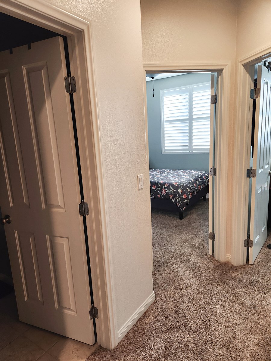 opposite side of the condo from the primary upstairs: bathroom door to the left (tub/shower combo), then the secondary bedroom