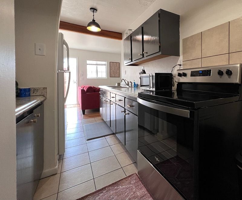 FULL KITCHEN with Fridge, Oven/Stove, Microwave, coffee maker, Brita Water Pitcher and all of the kitchen items you need to cook and enjoy meals!  Extendable dining table with chairs