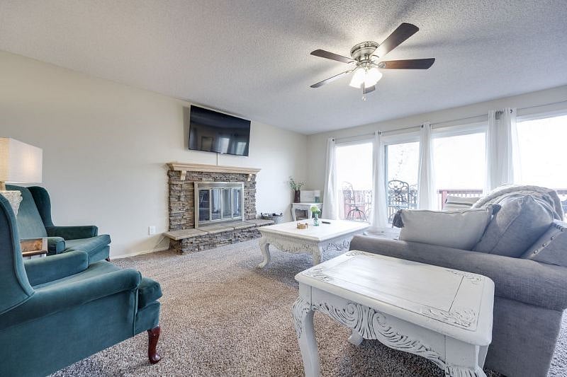 Large windows and sliding door with beautiful views of the trees and access to the back deck. Please note the fireplace is NOT operational.