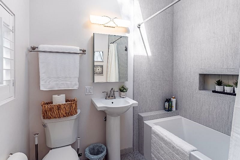 The full bathroom adjacent to the living room/office/bedroom has been updated and includes a bathtub with shower, toilet, sink and medicine cabinet and has been stocked with shampoo, conditioner, body wash, toilet paper, and plush towels.