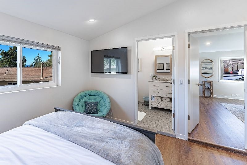 A large TV with an Amazon Firestick provides access to streaming services and a colorful chair allows for extra seating in the room.