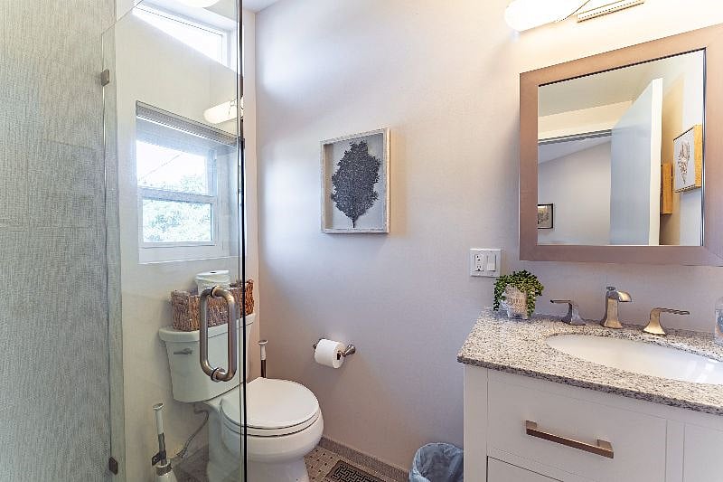 The ensuite bathroom has been updated and the windows bring in natural light. Toilet paper is provided and storage under the sink has a hair dryer and plush towels for your use. The walk-in shower includes complimentary shampoo, conditioner, and body wash.