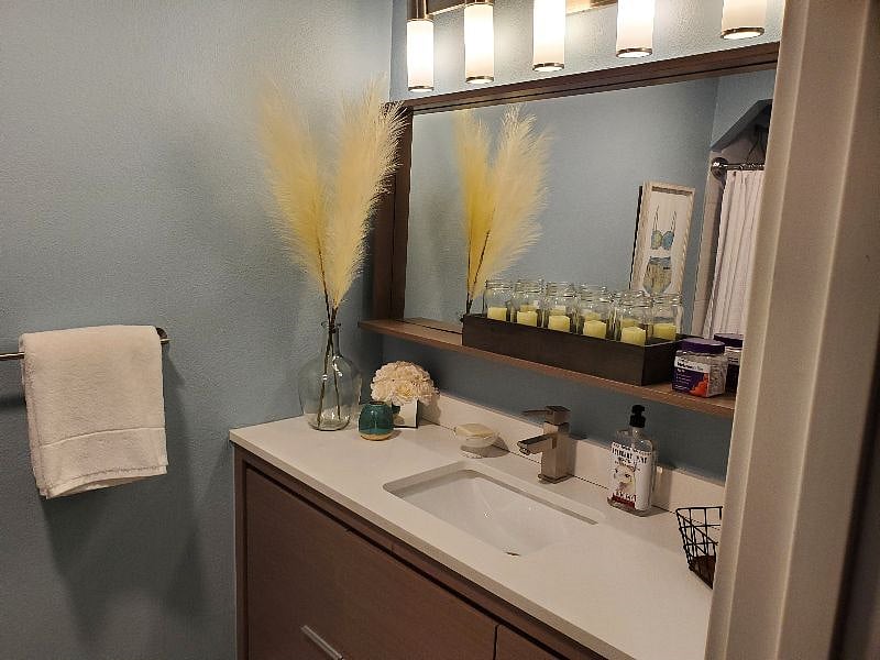 Shared bathroom with large vanity and plenty of storage space for 2