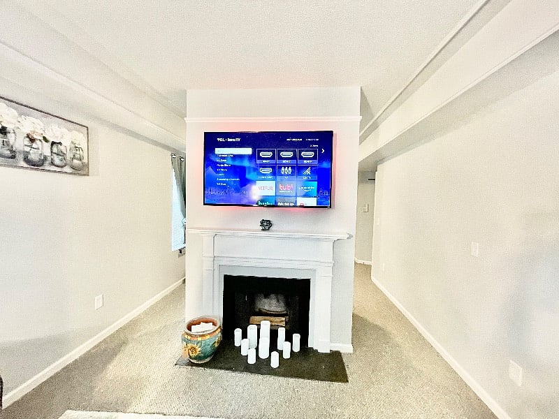 Living room with TV above fireplace.