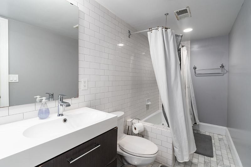 bathroom with two sinks and tub/shower