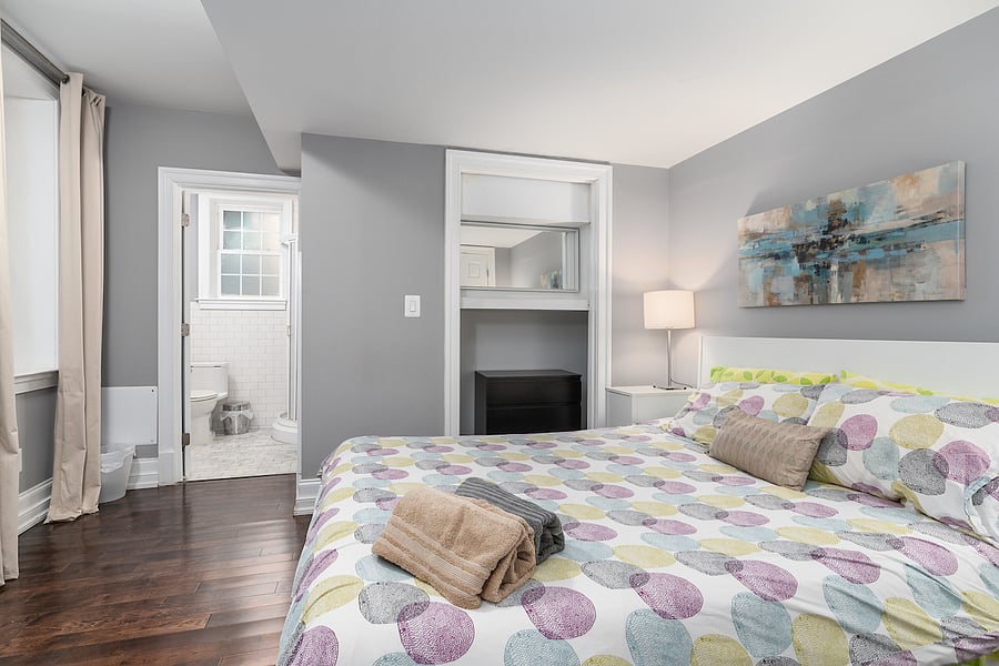 second bedroom with two dressers, closet, and en-suite bathroom