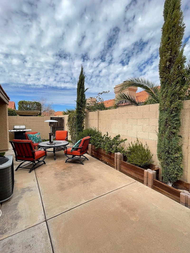 Backyard with table/chairs and grill. Plants all on automatic watering system. 