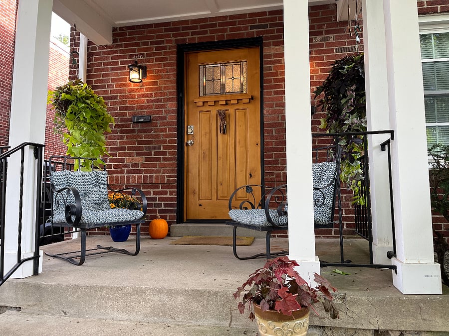 Covered porch, always lit with seasonal plants.