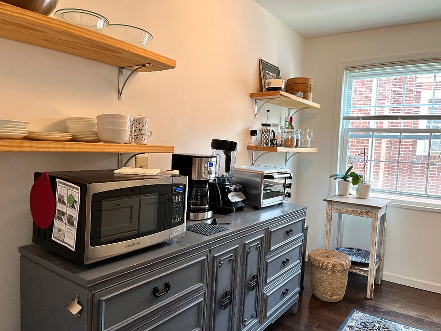 Shared kitchen with microwave, glasses and dishes