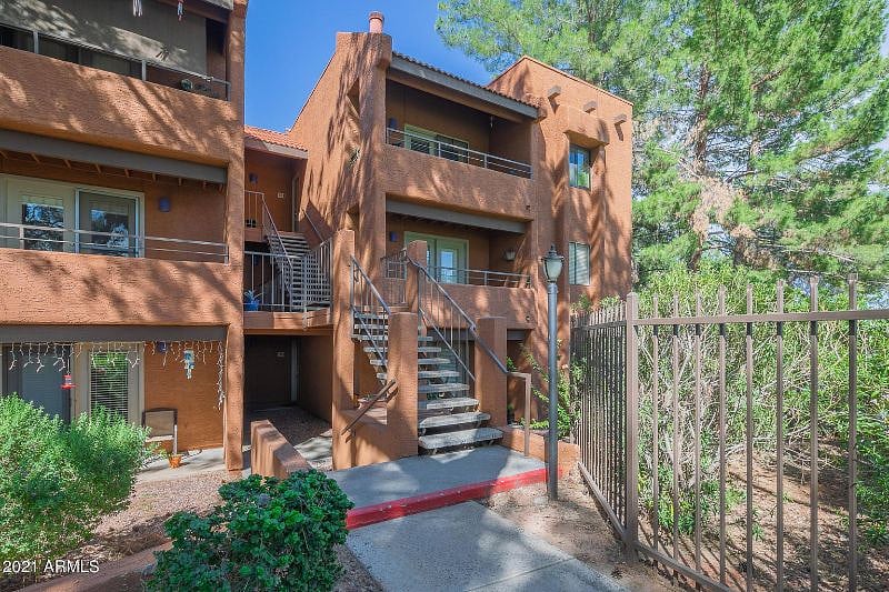 Mature shady pine trees and colorful plants make the charming exterior *