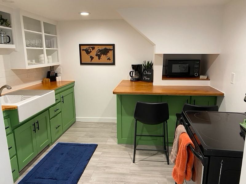Looking into the kitchen - recently updated with new (2024) full-size fridge/freezer, oven and range with vent hood, microwave, and bar/counter.