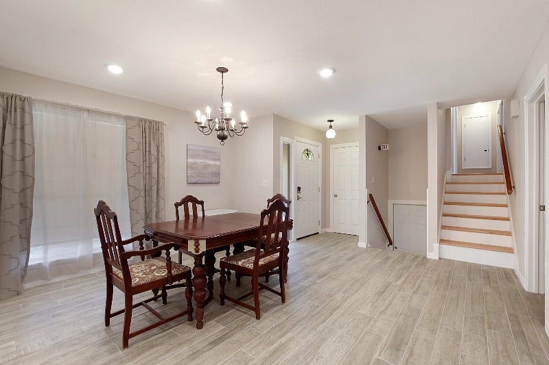 Front door, dining area, stairs down to shared laundry area in garage, stairs to second & third bedrooms with full bath