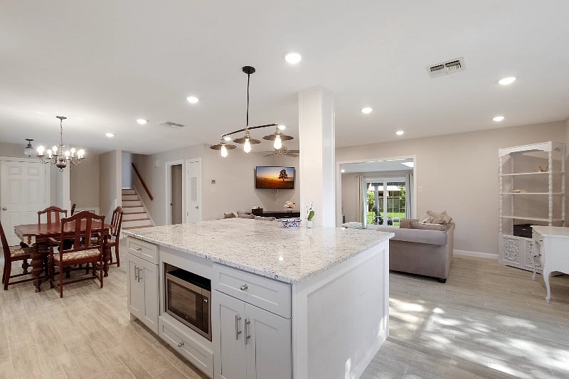 View from kitchen sink, dining area on left, stairs to two bedrooms and bath, door to master bedroom suite, large entrance to second living area with access to back yard