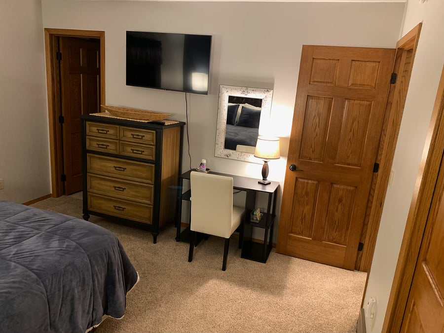 Primary bedroom amenities: smart TV, desk, power strip, chest of drawers.