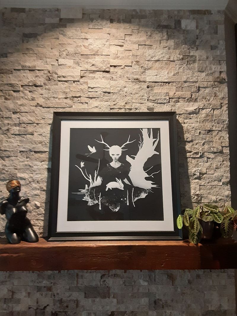Picture on barn beam mantle, over fireplace.