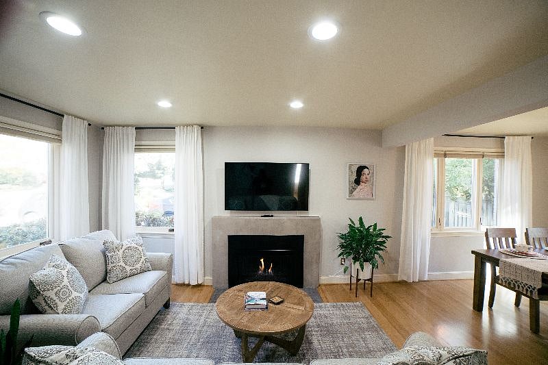 Relax after a busy day in this cozy living room featuring a gas fireplace, comfortable sofa and a brand new 55 inch smart TV