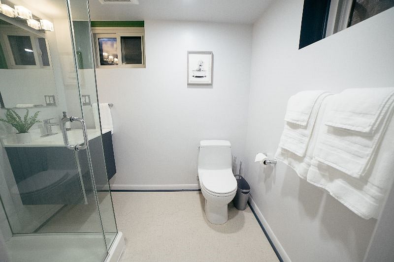 Newly renovated full bathroom with walk-in shower in the lower level basement next to the family room