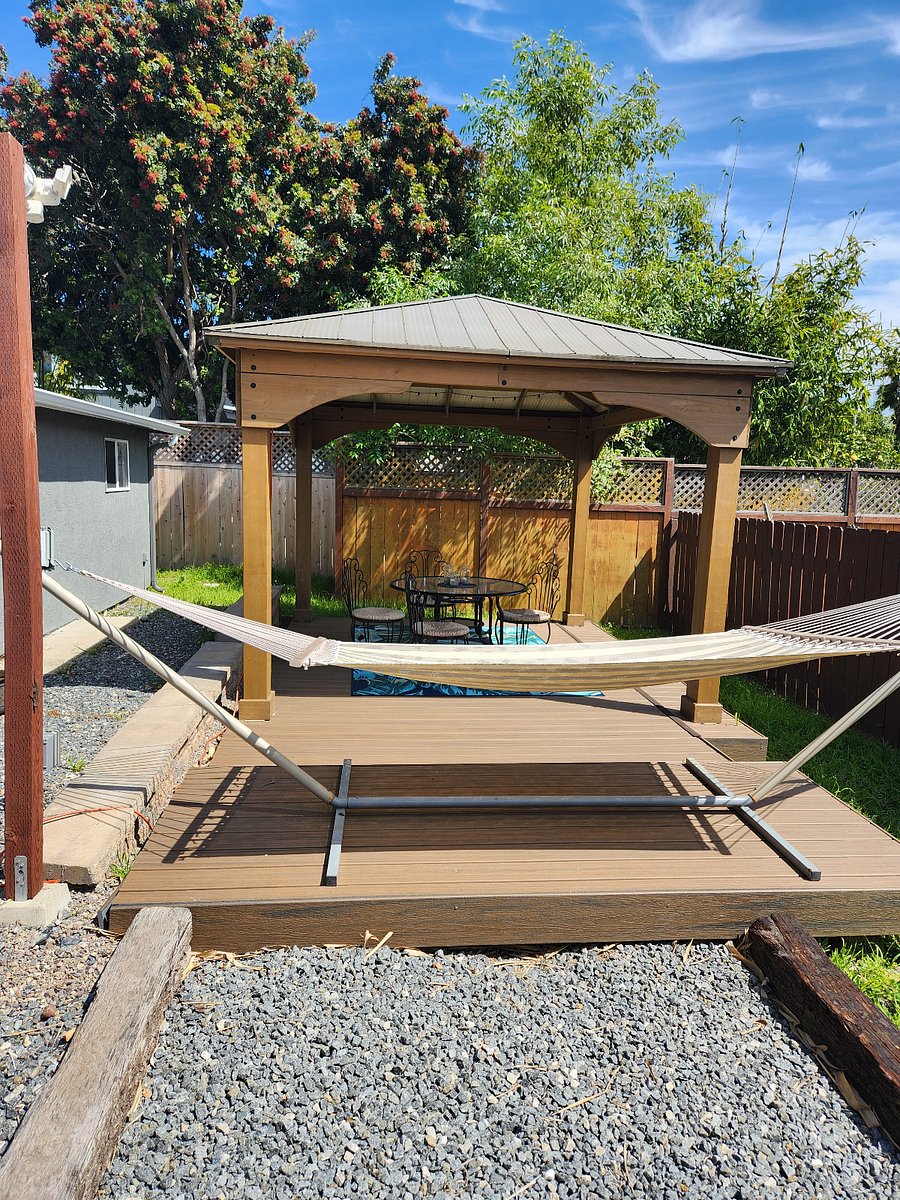 pergola and hammock on deck in back yard.