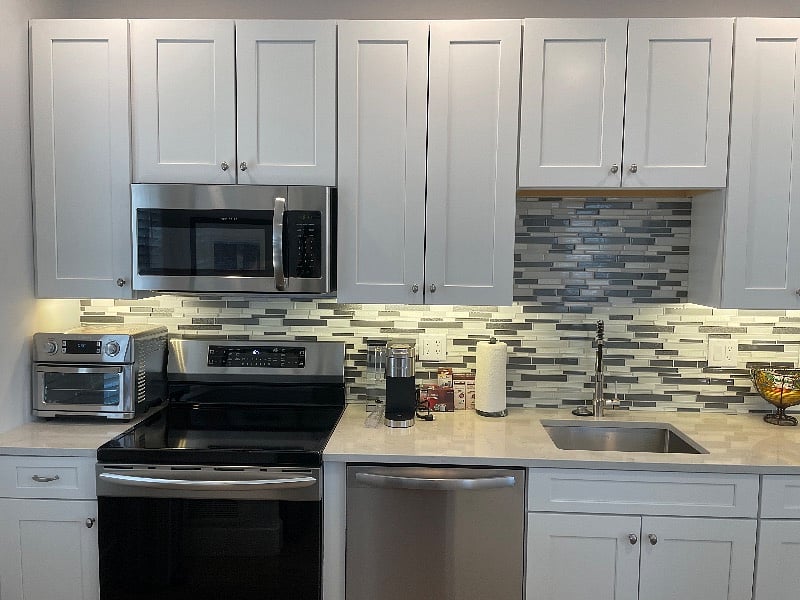 the kitchen has modern appliances including an induction cook top and oven. 