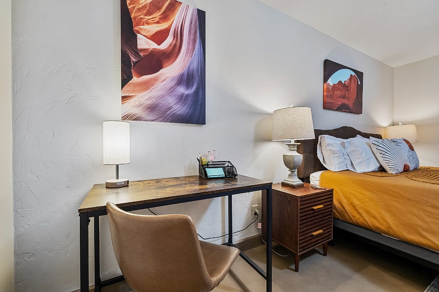 The primary bedroom is equipped with a desk and work lamp, offering a comfortable space if you need to work from home during your stay.
