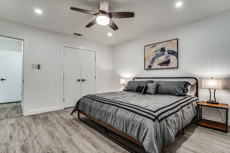 Spacious bedroom #1 with a king size bed, arm chair, and luggage rack