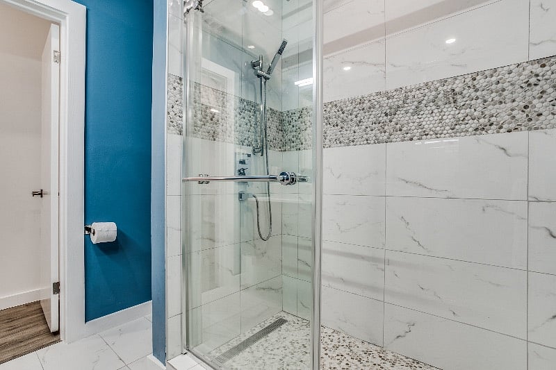 Spacious walk-in shower with rain shower and sliding glass door