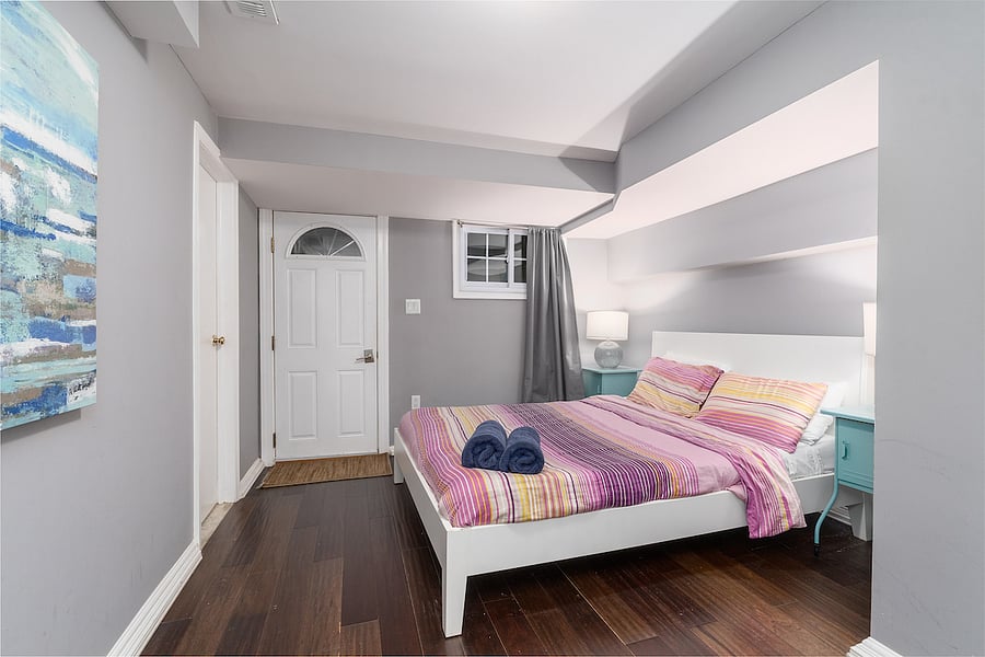 basement bedroom #1 with queen bed, private entrance, and entrance to bathroom. 