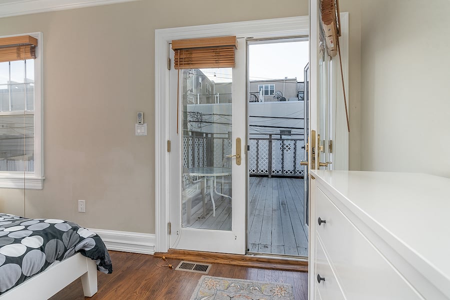 second floor back bedroom with queen bed and patio doors