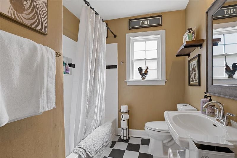 Bathroom with tub and shower and modern updates, providing a clean and functional space for extended stays near Cone Hospital in Greensboro NC.