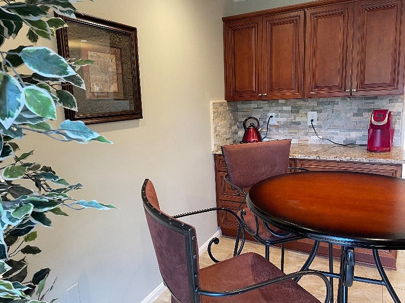 Next to the kitchen is a coffee nook with additional counter space for a coffee/tea station. There is seating, known to be used for zoom calls, and homework with natural lighting.