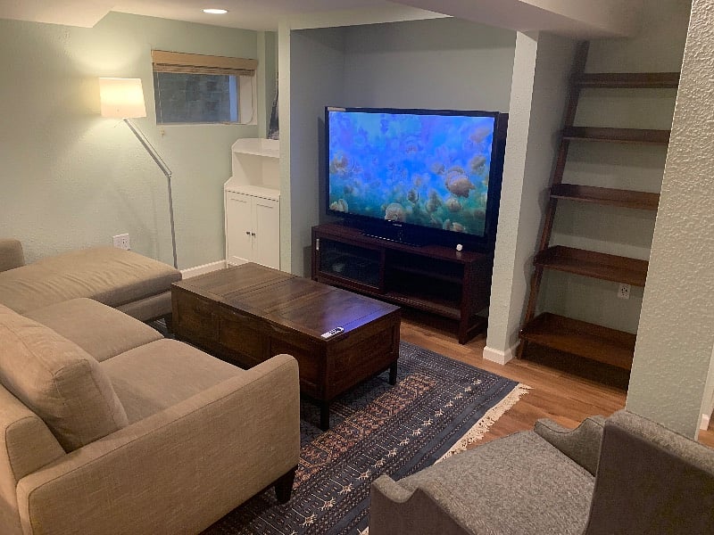 Coffee table with built-in storage, Apple TV, 60-inch plasma tv, USB outlets for convenience.