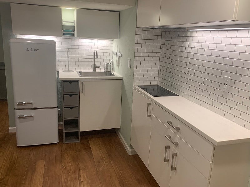 Subway tile backsplash, quartz countertops, magnetic knife rack, undercabinet lighting.