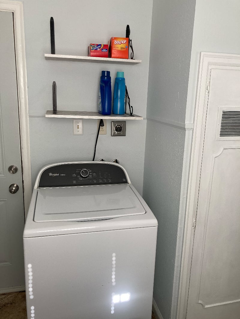 Top loading washer with laundry supplies.