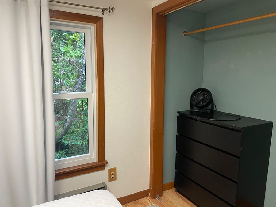 Bedroom closet & window with blackout curtain.