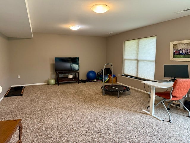 Full finished basement. Workout equipment with TV. Full sized bathroom, desk & chair, walkout sliding glass doors to backyard patio and raised bed garden.