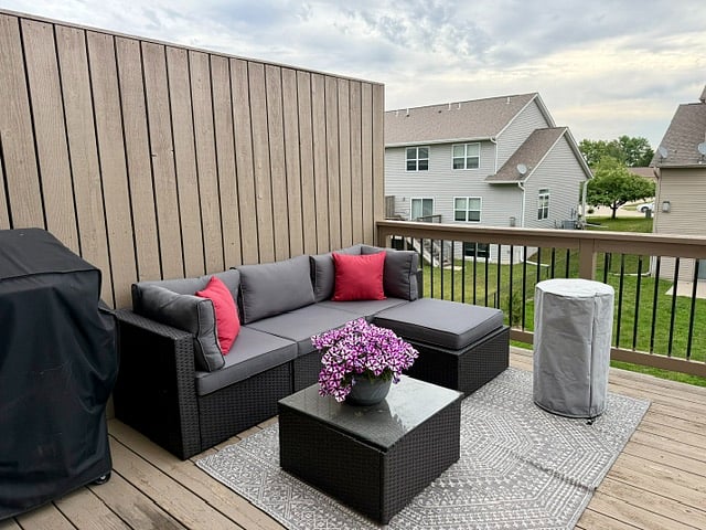 Furnished deck off dining room with grill, furniture, and tall fire pit.