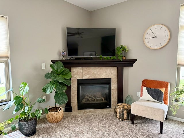 Main floor open concept living room with TV and gas fireplace.