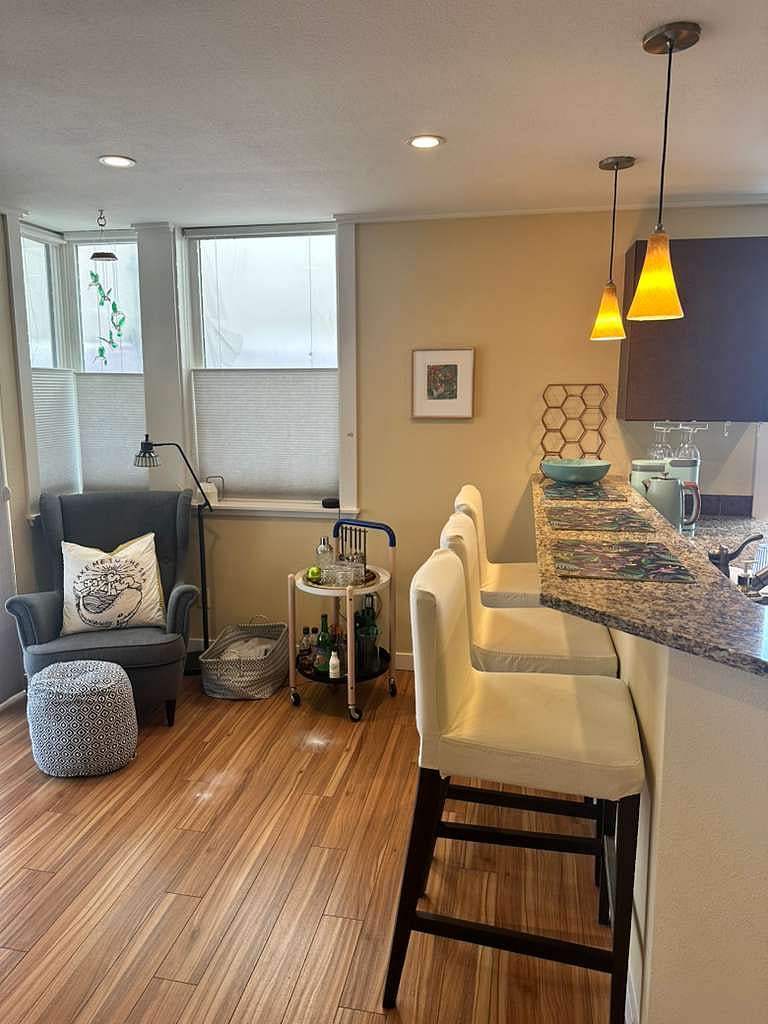 Living room space facing kitchen. Sliding door leads out to balcony.