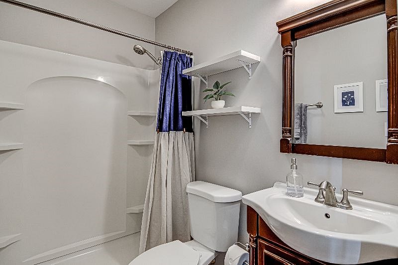 Bathroom | Standing shower with flexible, 3-setting shower head. Shelving, rack and door hooks for your convenience.
