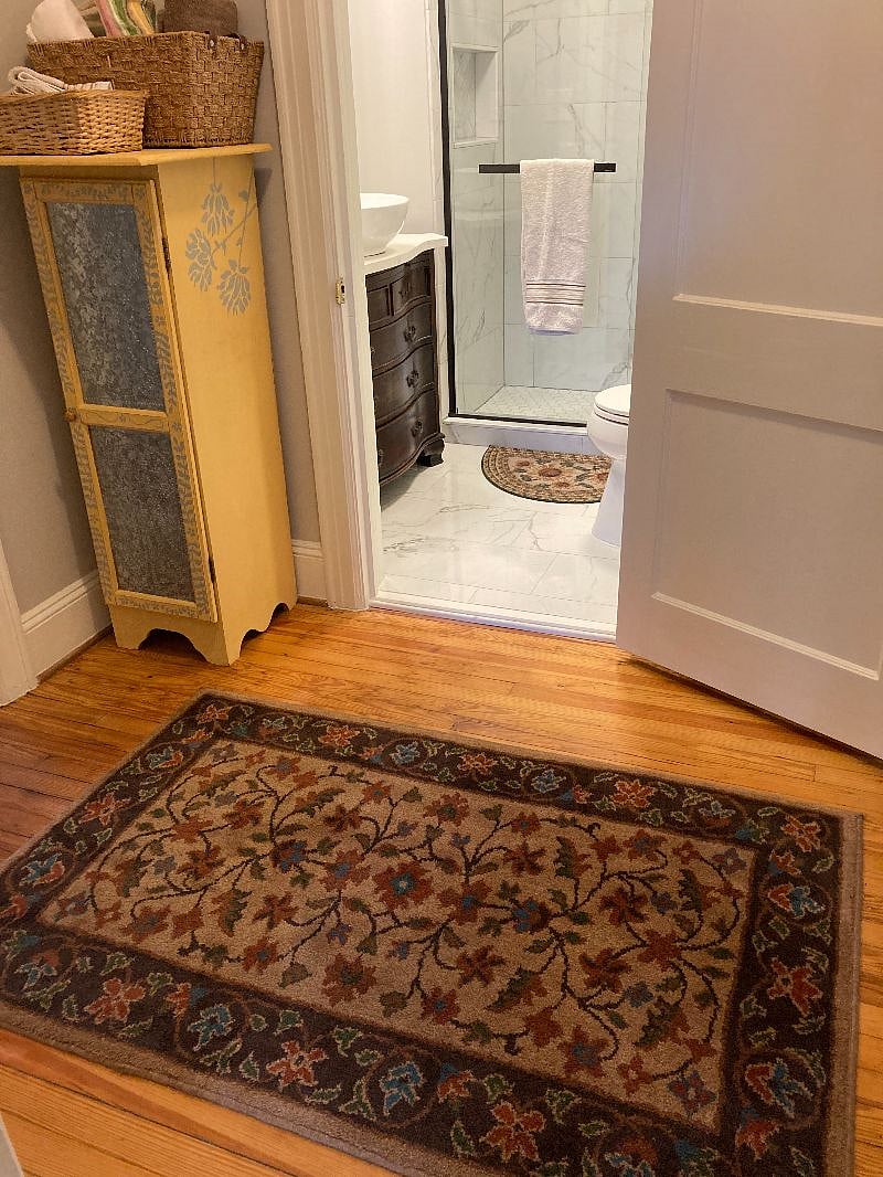 Antique painted cabinet in sunshine yellow, for storing towels, washclothes next to the bathroom.