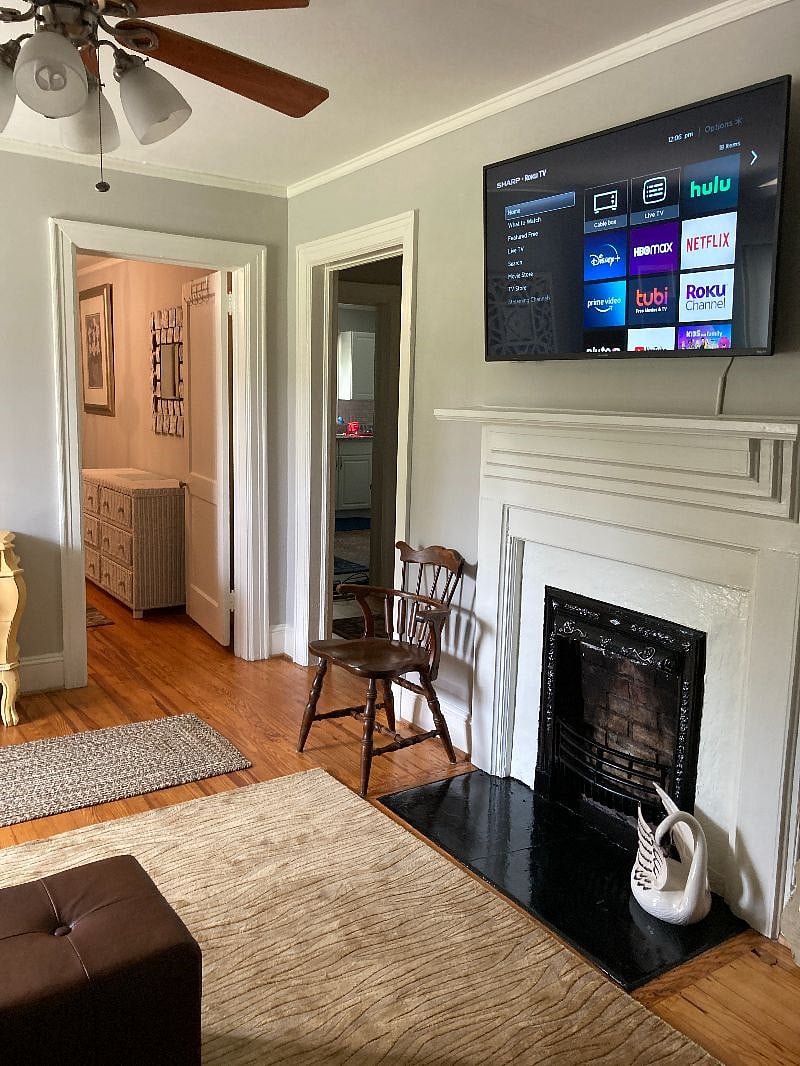 Original heartpine flooring through-out the home. off to the hallway is the kitchen, bathroom, main sleeping room. The bedroom off the living rm is the flex room and we recently added a tv on the wall in 2026.