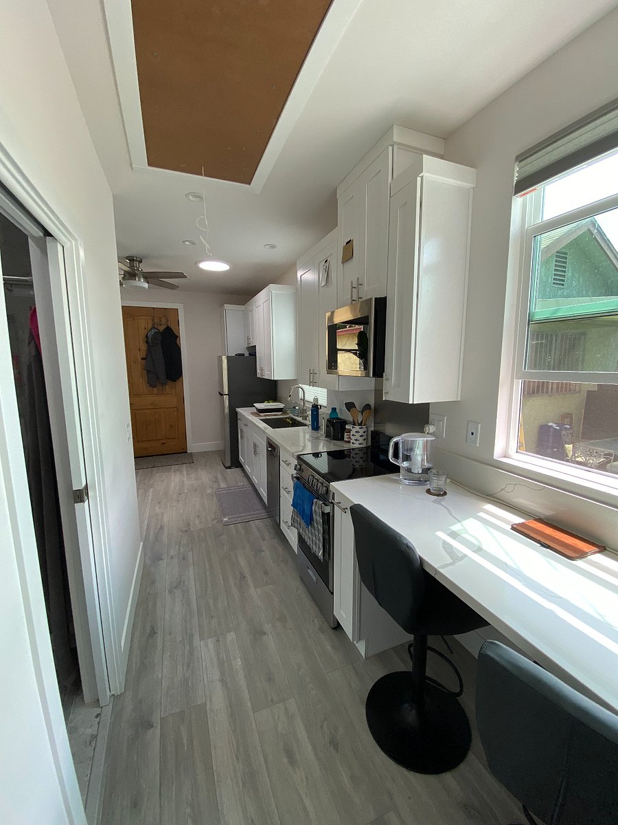 View of kitchen and front door from sleeping area.