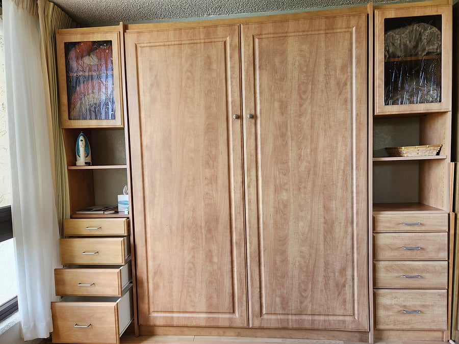 Closed Murphy bed closed with side drawers and cabinets.
