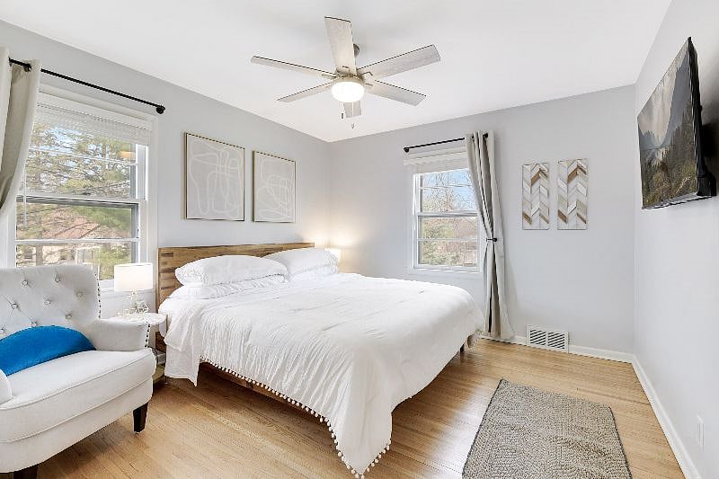 Main floor bedroom 1 - Large and bright with a KING-sized bed, sitting chair, smart TV and large closet with organizer for all of your things. Window blinds and BLACK OUT curtains for sleeping!