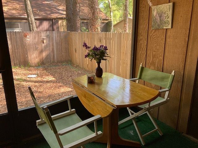 Table on screen porch, fenced back yard