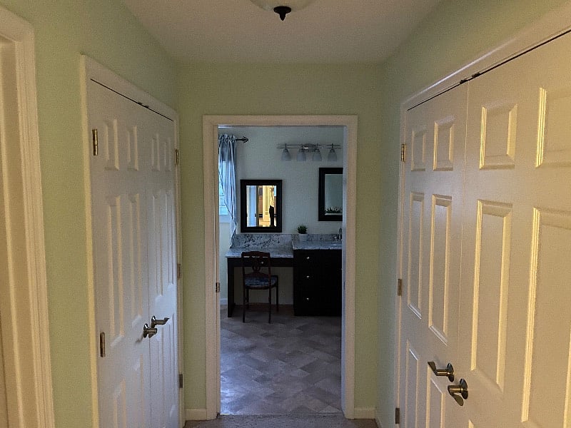 Hall from bedroom to bathroom with lighted closets on each side of hall.