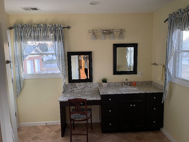 Large bathroom with vanity with granite top.