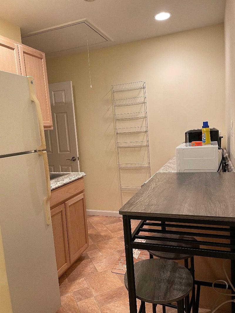 Kitchen area with full size fridge, microwave, and various appliances.