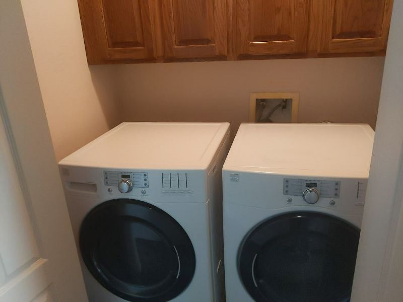 wood cabinets in laundry for storage electric dryer.