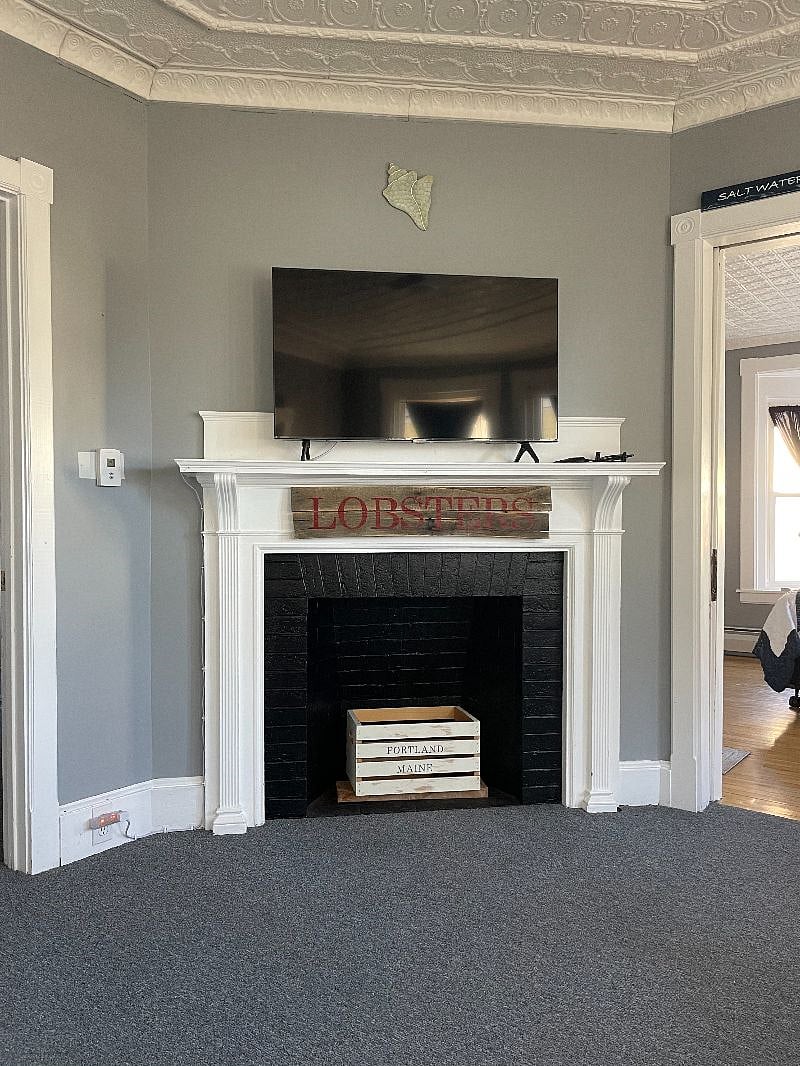 TV in living room (WIFI, Hulu, Netflix included) above a decorative fireplace.